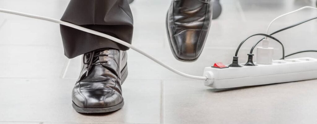 Man in suit and dress shoes walks into power cords