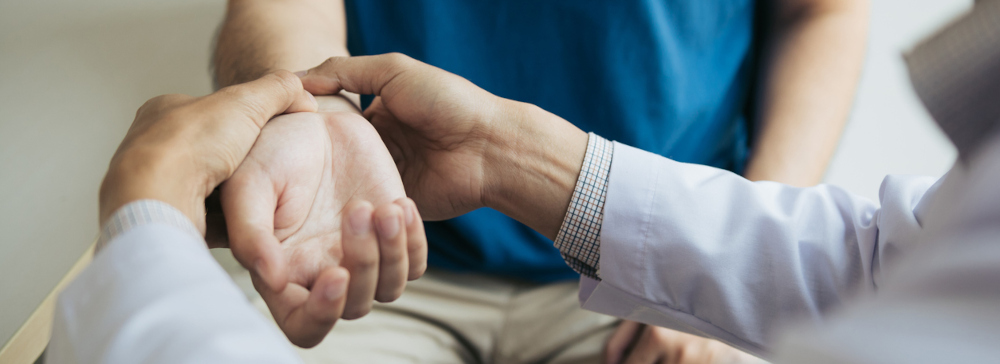 Doctor physically examining a person's injured wrist