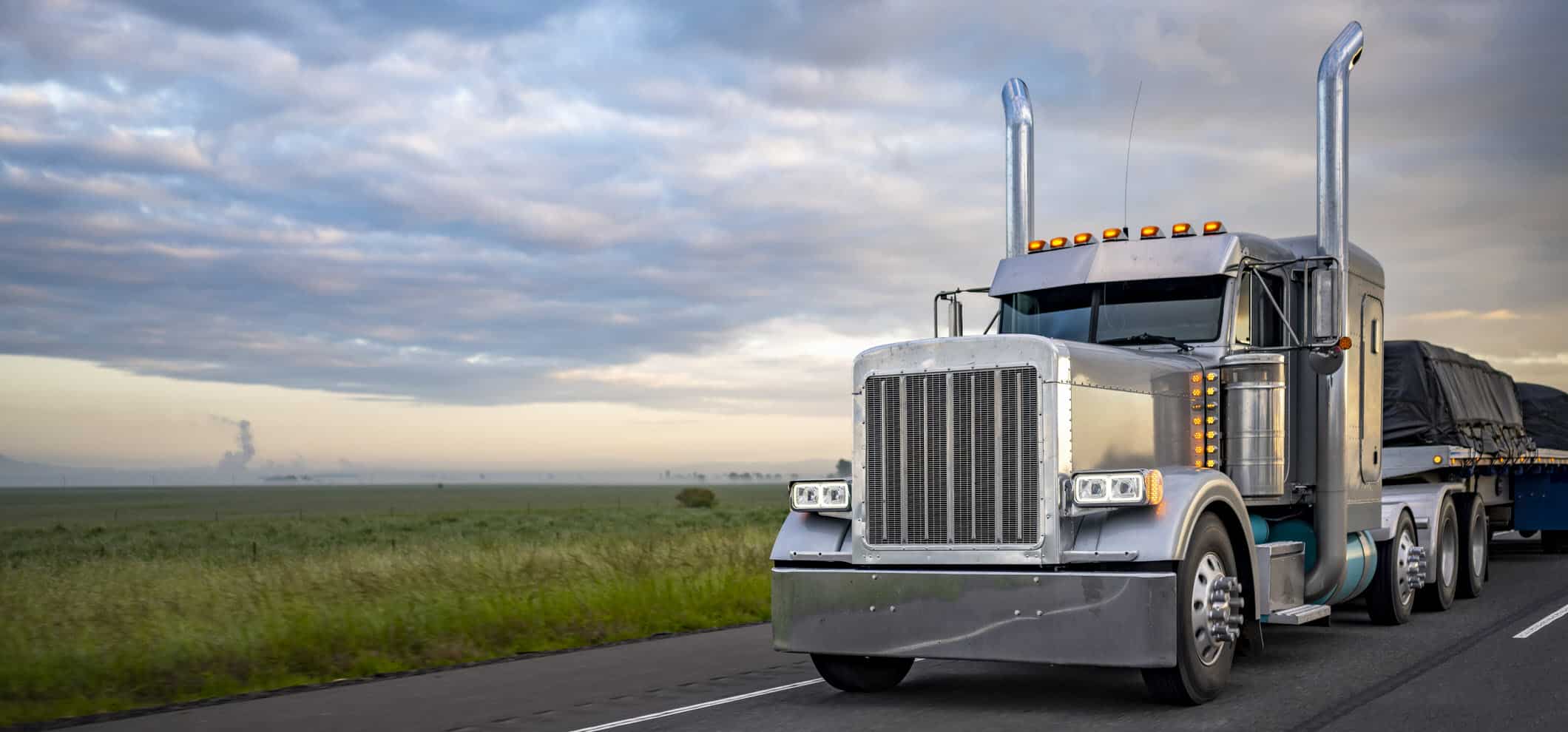 Truck Drives Down Highway at Dusk